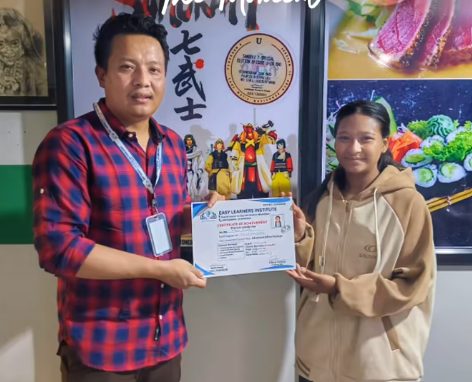 A student receiving an Easy Learners certificate from Anjit Lama
